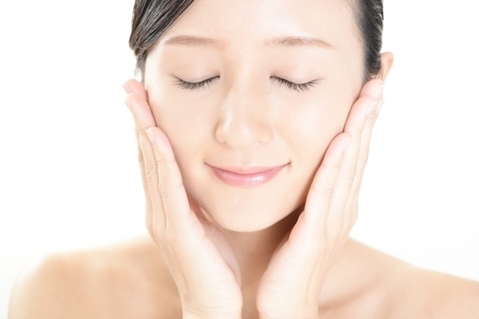 両手で頬を触る女性